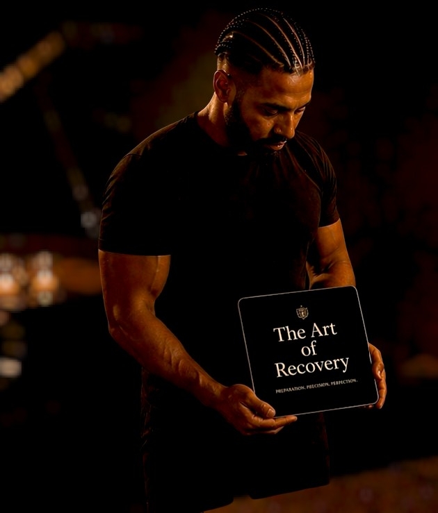 Joachim Norberg håller en skylt med texten The Art of Recovery i varmt mörker