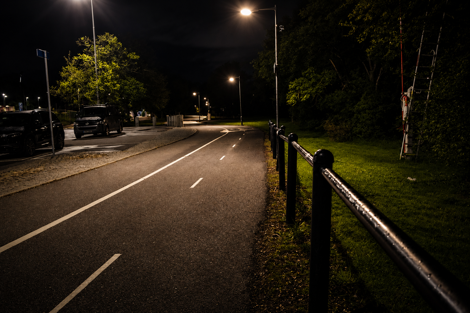 En väg upplyst av gatlyktor en stilla kväll — en bild om resa, riktning och återhämtning efter dagen